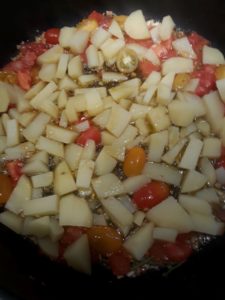 Kartoffeln und Tomaten in die Pfanne